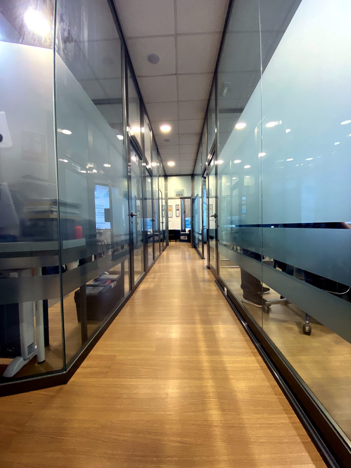 Pasillo con oficinas privadas acristaladas en Coworking Oleiros